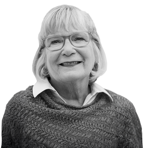 Older woman wearing glasses and a sweater smiling